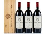 three bottles of wine and a wooden box on a white surface