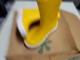 une chaussure jaune posée sur une boîte en carton