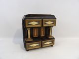 une petite commode en bois à quatre tiroirs
