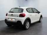 the rear of a white car is parked in a large room
