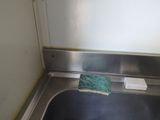 a metal sink with a green sponge in it
