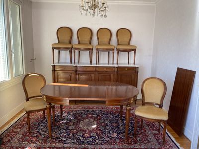 une table de salle à manger avec des chaises et un tapis au sol