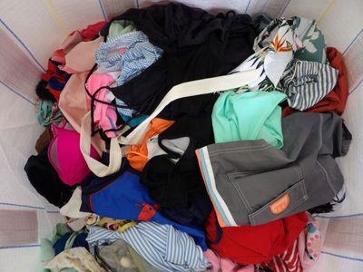 a basket full of clothes that is sitting on the floor