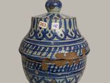 a blue and white vase with a lid on a table