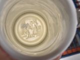 a person holding a cup with a picture of a man and a woman on it
