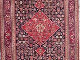 un vieux tapis accroché au mur près d'une fenêtre