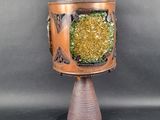 a small vase with a green and yellow decoration on it