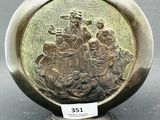 un vase en argent orné d'une image représentant un groupe de personnes