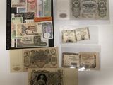Plusieurs types de billets de banque sont exposés sur une surface blanche