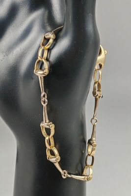 a close up of a mannequin head with a chain around it