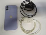 un iPhone violet auquel est branché un chargeur