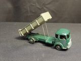 a green toy truck with a dump truck attached to it
