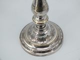 a silver candle that is on a white table