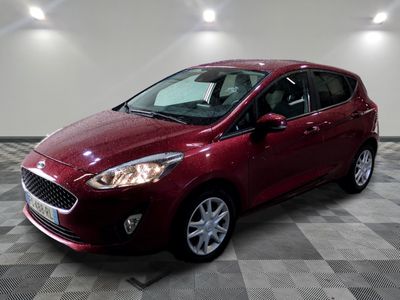 the red ford fiesta is parked in a room with a checkered floor