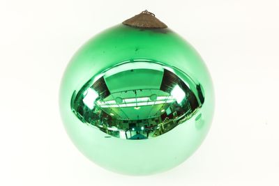 a green glass ornament with a wooden top