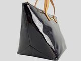 a close up of a black handbag with a brown handle