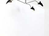 two black and white lights hang from the ceiling in a white room