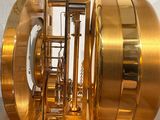 a golden clock inside of a glass case on display