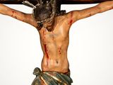 a statue of jesus on the cross with a sign on it