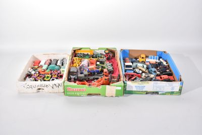 Deux boîtes contenant un assortiment de petits véhicules jouets sont posées sur une surface blanche.
