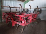 une rangée d'outils agricoles entreposés dans une remise