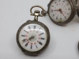 several different types of pocket watches sitting on a white surface