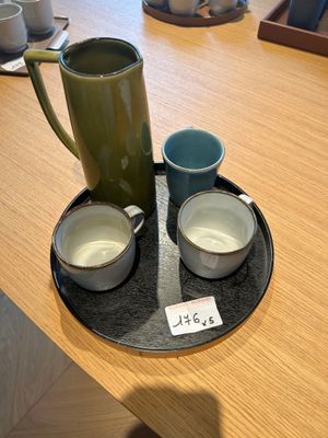 deux tasses et un pichet posés sur un plateau, lui-même posé sur une table