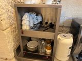 a silver shelf with a bunch of dishes and cups on it