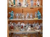 de nombreuses figurines exposées sur une étagère dans une pièce