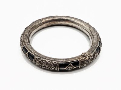 un gros plan d'un bracelet en argent orné de pierres noires