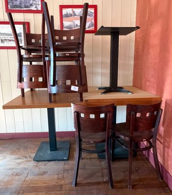des tables et des chaises dans un restaurant avec des tableaux accrochés au mur