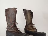 pair of brown leather boots with laces on them on a white surface