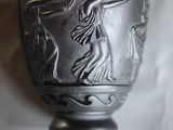 un vase en argent orné d'un motif sur fond blanc