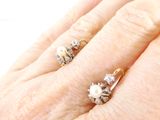 a woman ' s hand with two rings on it