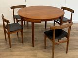 une table en bois entourée de quatre chaises, posée sur un parquet en bois dur