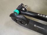 a black scooter with a green wheel on the floor