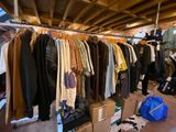 a lot of clothes hanging on a rack in a room