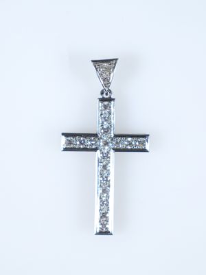 un gros plan d'un pendentif en forme de croix en diamant sur fond blanc