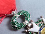 a red ribbon with a green wreath and a star on it