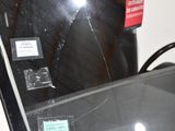 a picture of a broken windshield with a sticker on it