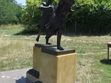 une statue en bronze représentant un homme à cheval, posée sur un socle