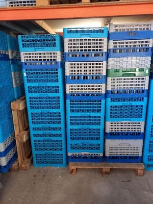 une grande pile de caisses bleues et blanches dans un entrepôt
