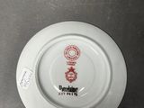 a white plate with a red and black design on it