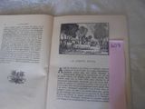 un livre ouvert posé sur un lit, sur lequel est collé un autocollant rose