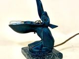 une statue bleue représentant un oiseau avec un crochet sur la tête