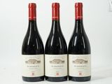 trois bouteilles de vin rouge posées sur une table blanche