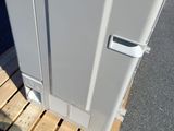 a white refrigerator sitting on a pallet next to a door