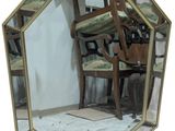 a mirror with a chair and a chair in front of it