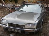 a silver car that is parked in the dirt