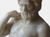 a statue of a man with a beard holding his hand to his ear
